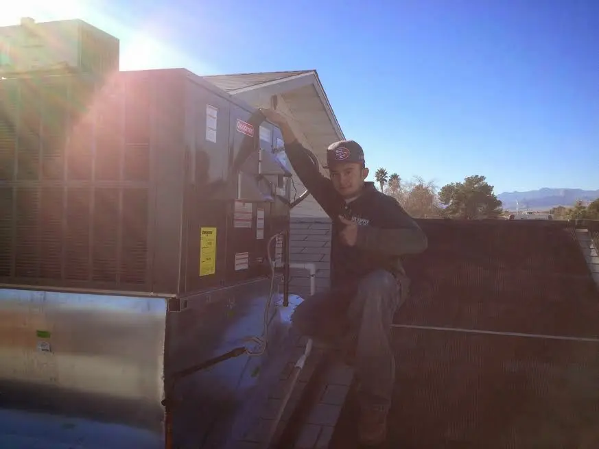 HVAC technician performing Heat Pump Repair on a rooftop unit in Fort Carson